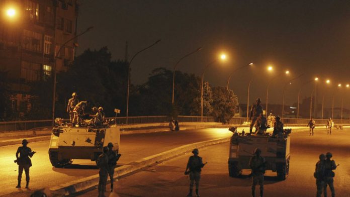 Army soldiers take their positions on the bridge towards members of the Muslim Brotherhood and supporters of Mursi standing guard around Cairo University and Nahdet Misr Square in Giza, on the outskirts of Cairo