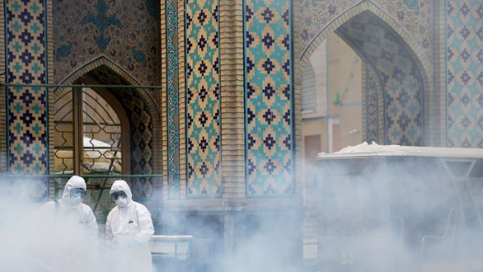 FILE PHOTO: Members of the medical team spray disinfectant to sanitize outdoor place of Imam Reza's holy shrine, following the coronavirus outbreak, in Mashhad