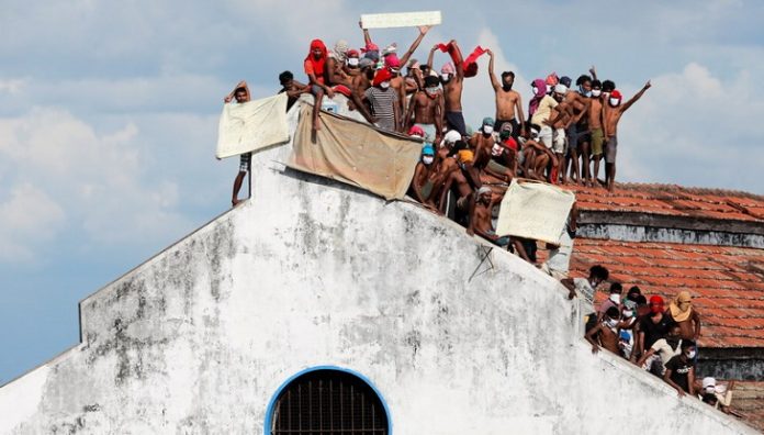 Inmates protest on the top of a prison building, in Colombo