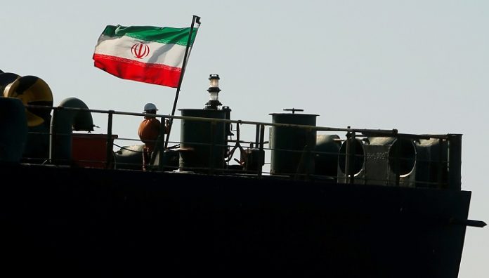FOTO DE ARCHIVO. Un tripulante iza la bandera iraní del petrolero iraní Adrian Darya 1, anteriormente llamado Grace 1, en el Estrecho de Gibraltar, Andalucía, España